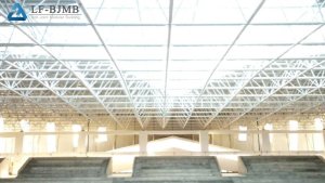 Bolted Space Frame Roof over Stadium Stands Interior view of a large-span bolted space frame roof grid over stadium stands, showing the steel tube and ball node structure spanning the venue without columns